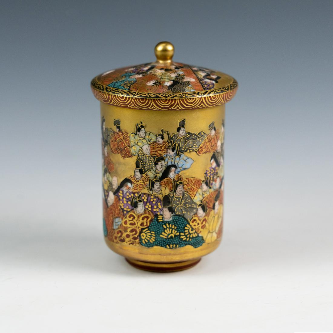 Kutani Hyakunin Isshu 100 People (Poets) 1 Poem Tea Cup: A Kutani Hyakunin'isshu 100 People (Poets) - 1 poem tea cup with lid having gold ground with intricately painted scene depicting 100 poets and poem of composition written on the interior of the cup.