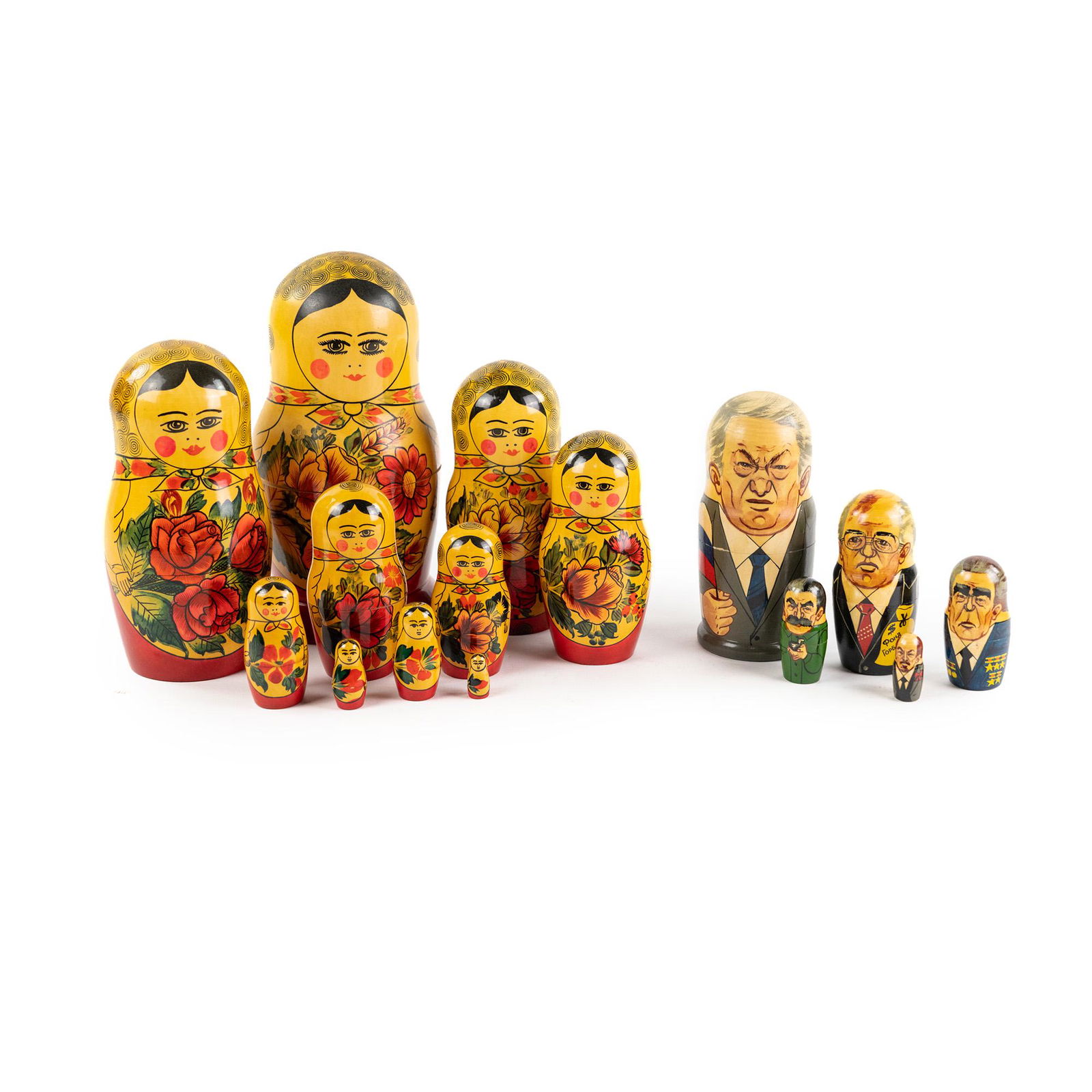 (2) USSR Russian Matryoshka Nesting Dolls: A pair of vintage Russian matryoshka wood nesting dolls, one having a traditional depiction of Russian women with flower motifs, and one being a series of caricatures depicting various Russian politic
