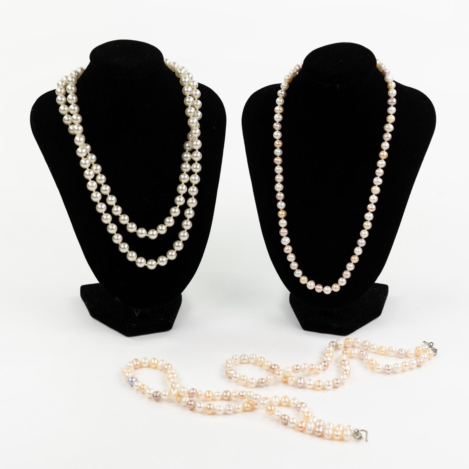 (4) Cultured and Natural Pearl Necklaces: A group of four (4) pearl necklaces including a multi-strand cultured pearl necklace with clip clasp, and three natural pearl necklaces having champagne and purple colored pearls with hook clasps. Mea