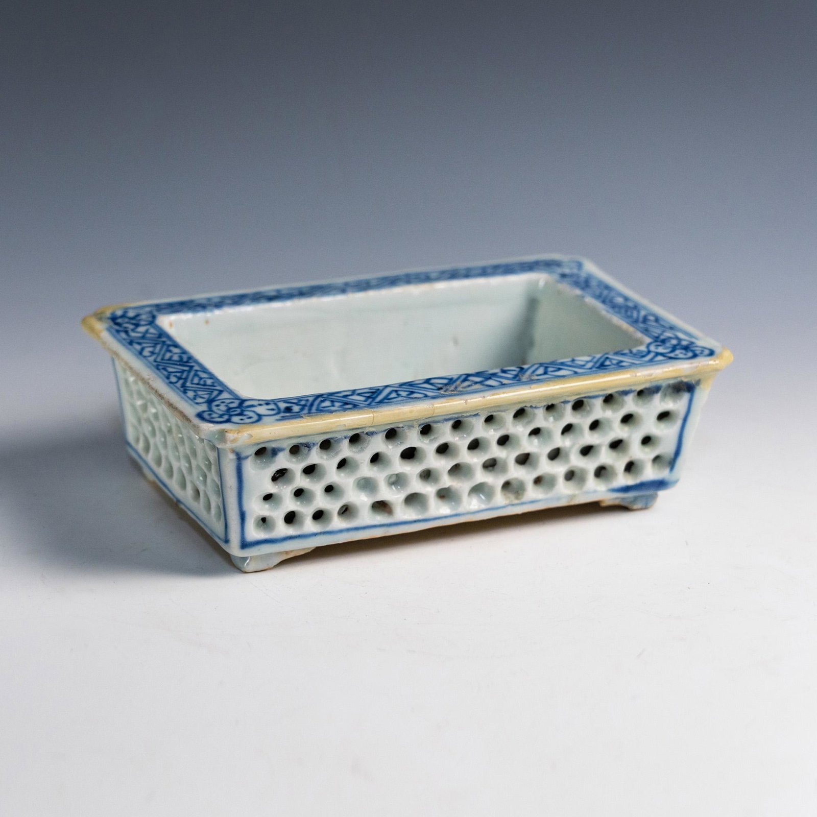 Chinese Qing Blue and White Narcissus Flower Pot: A Chinese Qing Blue and White porcelain Narcissus flower pot having blue border and repeating hole pattern on all four sides on footed base.