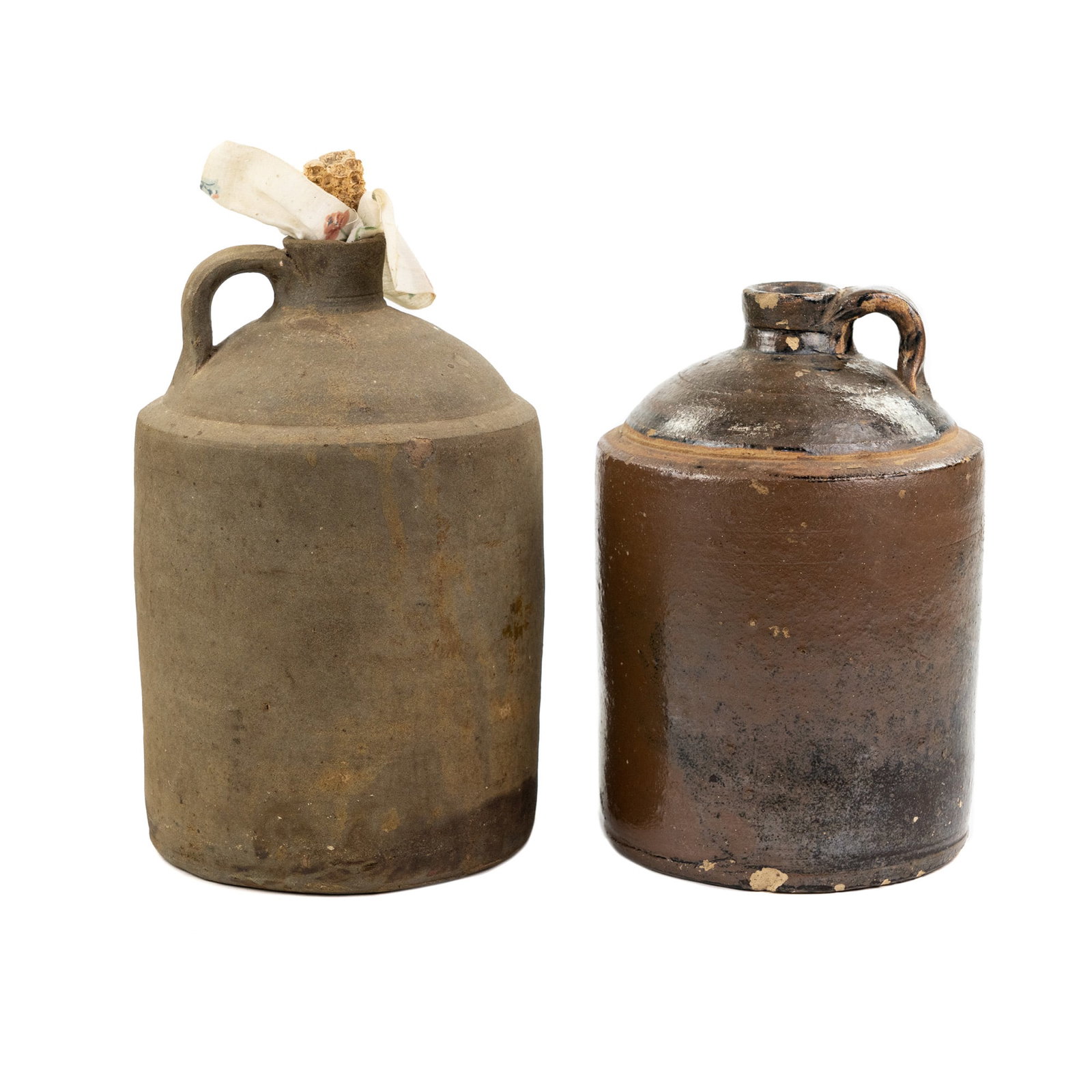 (2) Edward Leslie Stork Stoneware Jugs: A group of two (2) stoneware jugs including an Edward Leslie Stork piece with strap handle and stamped 'E.L. Stork, Orange GA' and one unmarked jug with loop on rim and corn cob cork. Measurements are