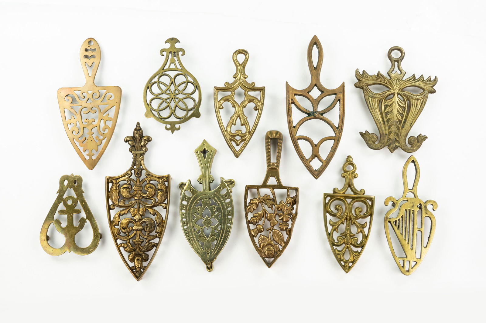 Grouping of Iron and Brass Trivets: A large grouping of antique and vintage various brass cast trivets for irons.