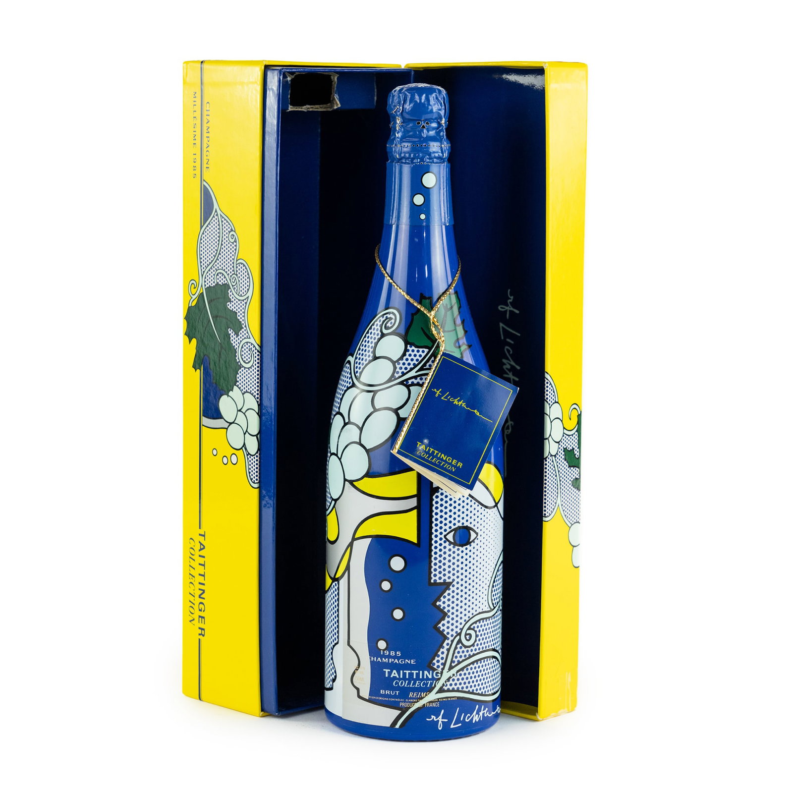 1985 Taittinger Limited Ed. Lichtenstein Champagne: A sealed 1985 Brut champagne bottle featuring screen printed Roy Lichtenstein artwork on the label along with his printed signature near the bottom; two bottles having a printed information tag tied t
