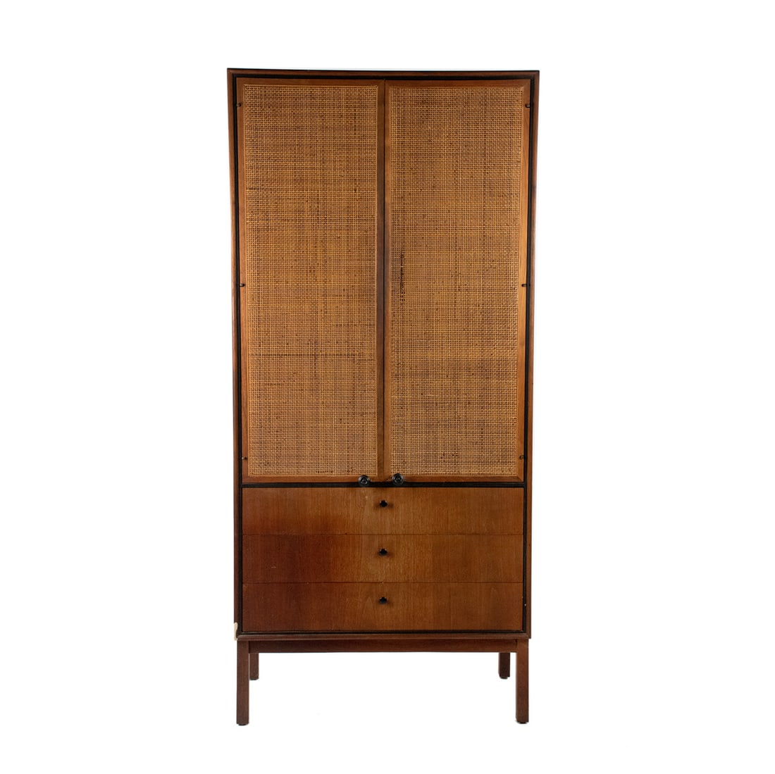 MCM Walnut Wardrobe by Jack Cartwright for Founders: A Mid-Century Modern Jack Cartwright for Founders Furniture walnut wardrobe cabinet having two doors with cane panels that open to three interior shelves, and three lower drawers featuring the origina