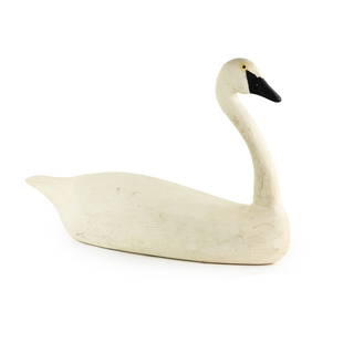 Hand Carved Trumpeter Swan Wood Decoy: An antique hand carved Trumpeter Swan wood decoy having small plastic eyes and painted black, white, and yellow. Stickered on underside E.C RS-2.