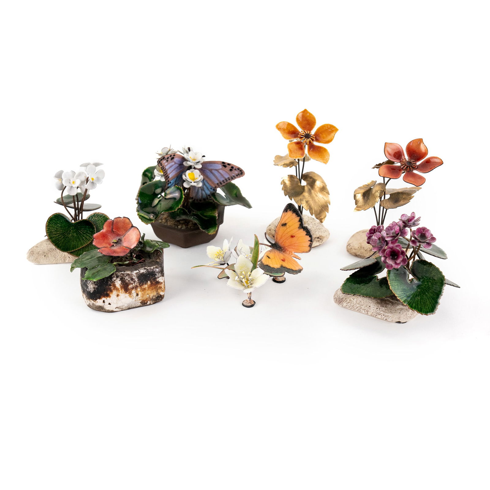 (7) Group of Bovano Enameled Glass Flower Figurines: A group of (7) Bovano enameled copper figurines; each depicting various flowers, some with butterflies, growing from stones. Each stickered 'Bovano' on underside.
