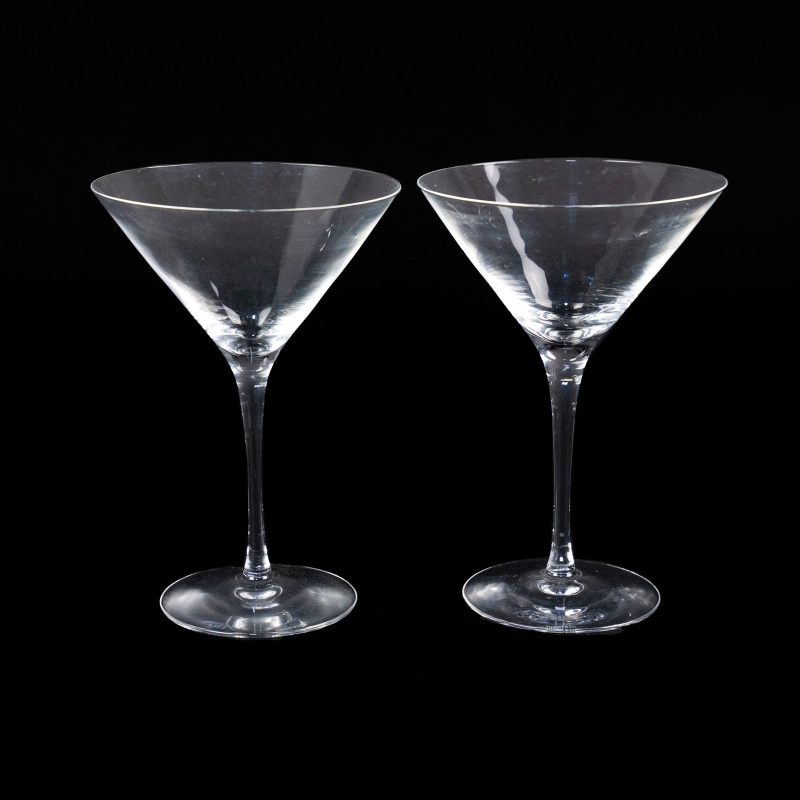 Pair of Tiffany & Co. Martini Glasses: A pair of Tiffany & Co. martini glasses having no pattern and thin stems. Marking etched onto each base.