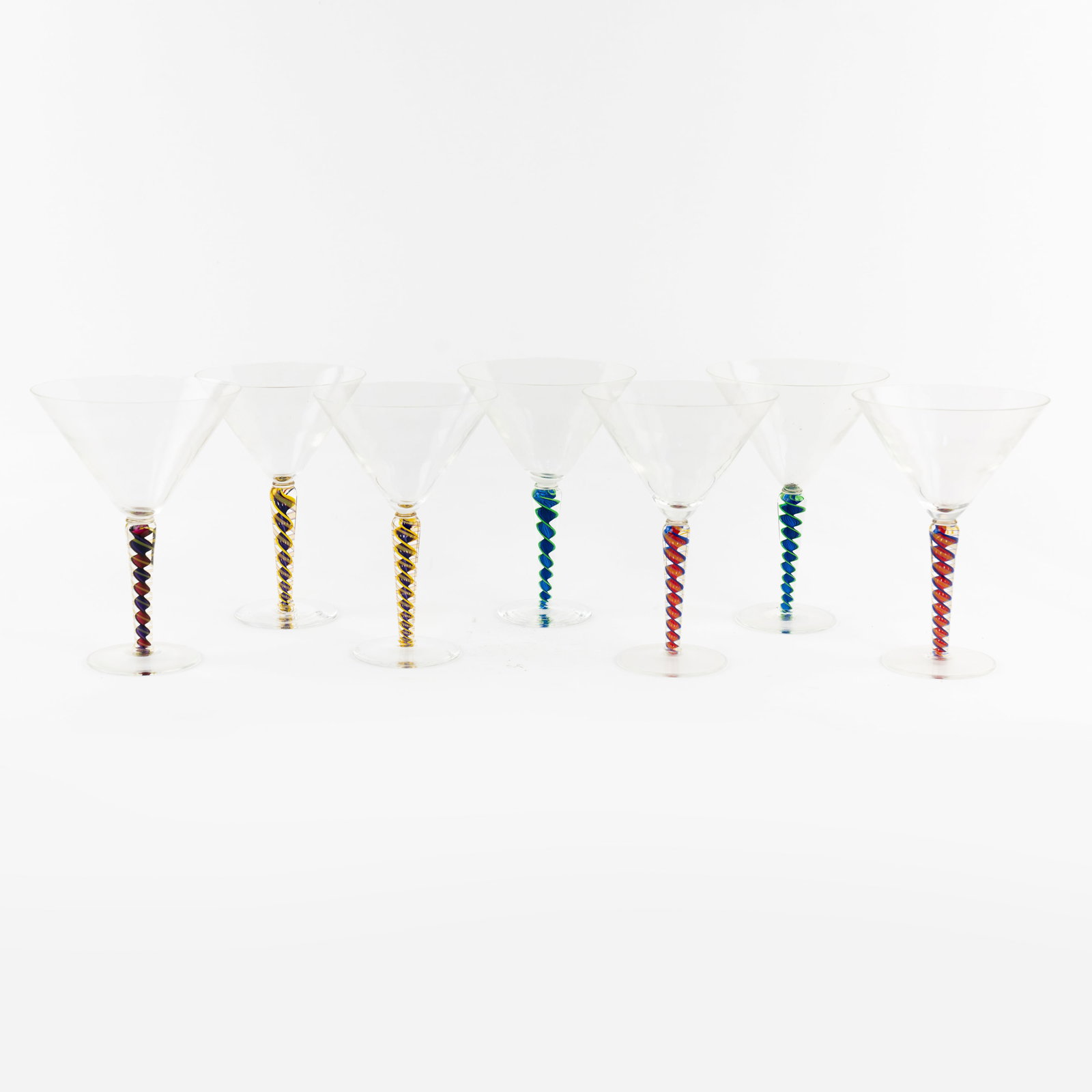 (7) Set of Nadal Art Glass Martini Glasses: Artist Name: James Nadal Studio: Nadal Glass Location: Canandaigua, New York Medium: Studio art glass Description: A set of (7) hand blown art glass martini glasses with spiral motif stems. Each incis