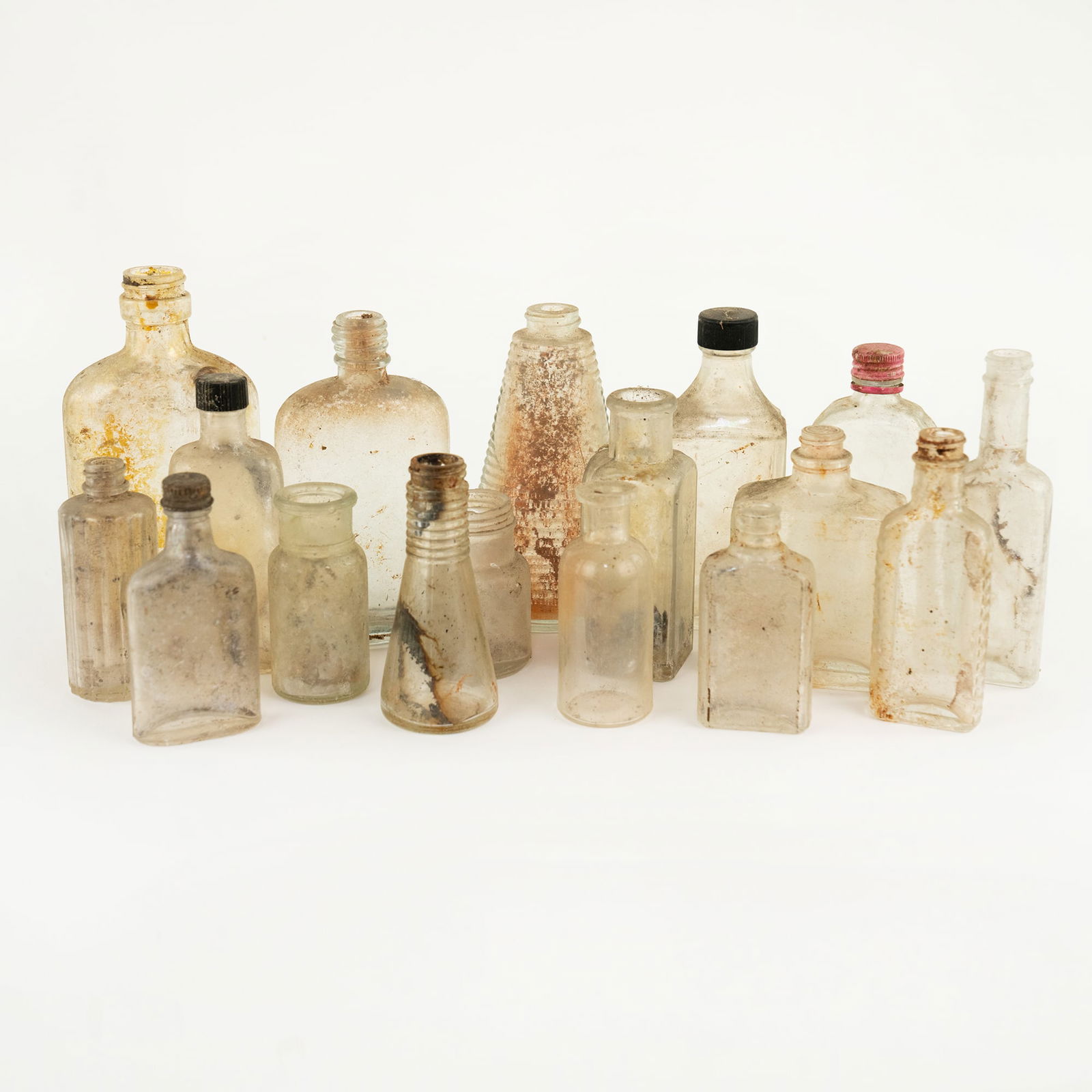 Collection of Antique Assorted Glass Bottles: A collection of assorted antique glass bottles, flasks and vials in varying shapes and sizes.