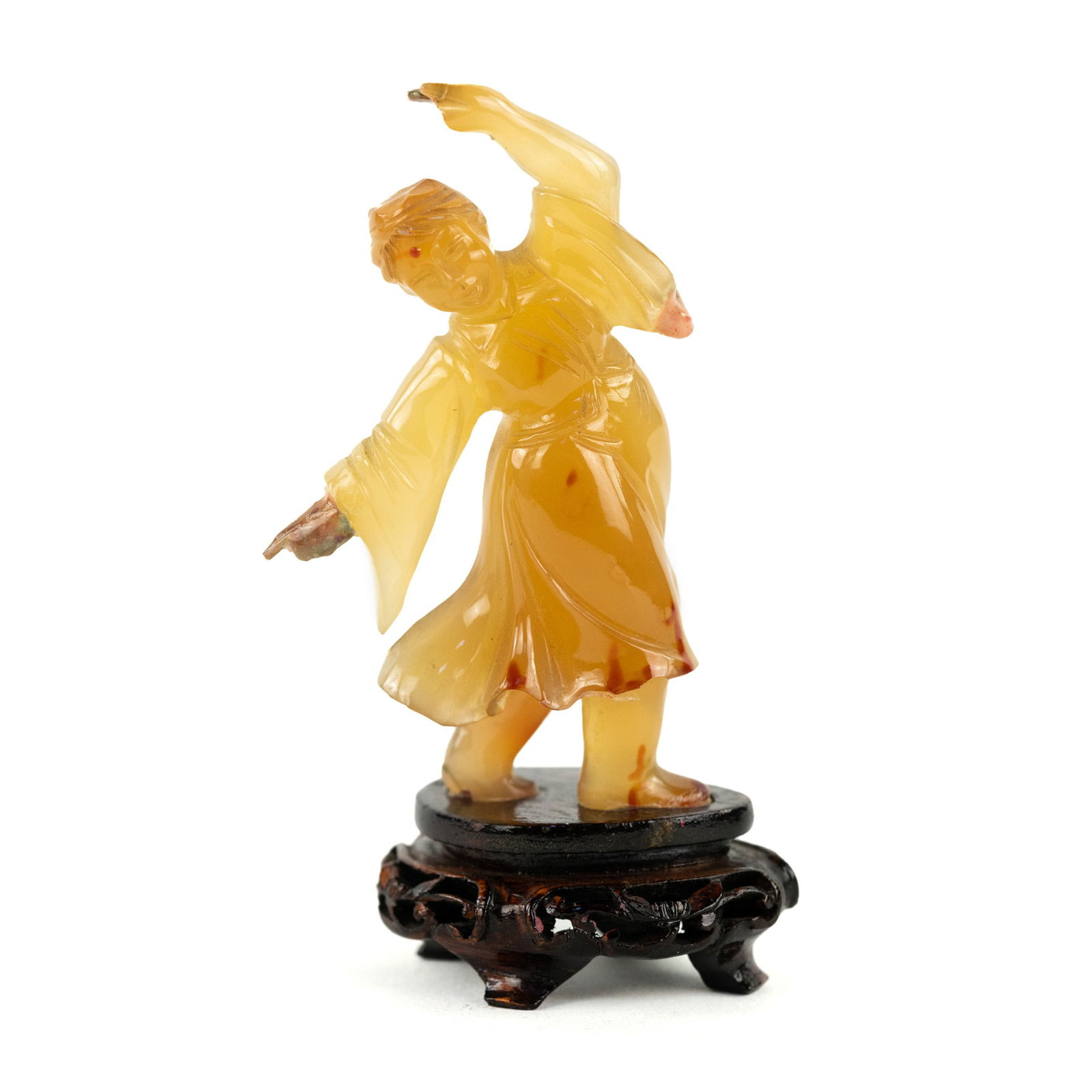 Indian Carved Carnelian Dancing Woman Figurine: An Indian carved carnelian or agate figurine depicting a woman in a flowing robe dancing. Presented on a wooden plinth.