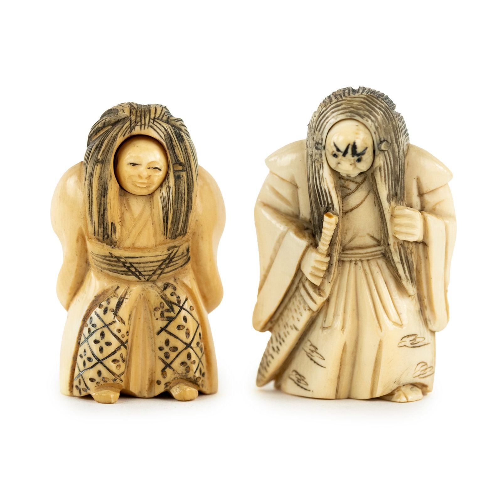 Pair of Japanese Carved Bone Kabuki Figure Netsukes: A pair of Japanese carved bone netsukes depicting Kabuki dancers featuring faces that rotate to show an alternate expression on the dancer. Both incised signed on underside.