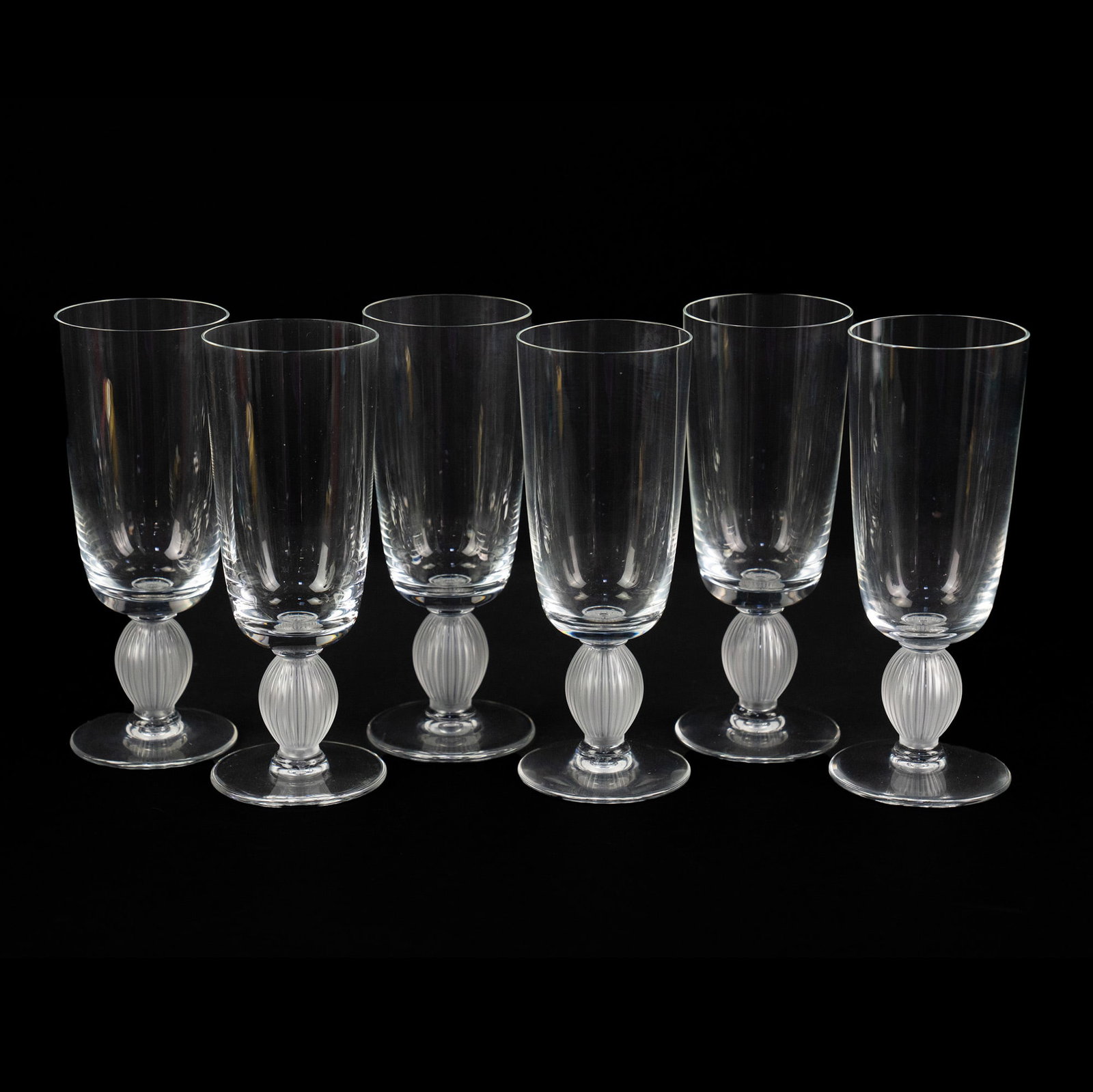 (6) Lalique Langeais Crystal Champagne Flutes: A set of (6) Lalique Langeais crystal champagne flutes having frosted and fluted stems. Incised marked on underside.