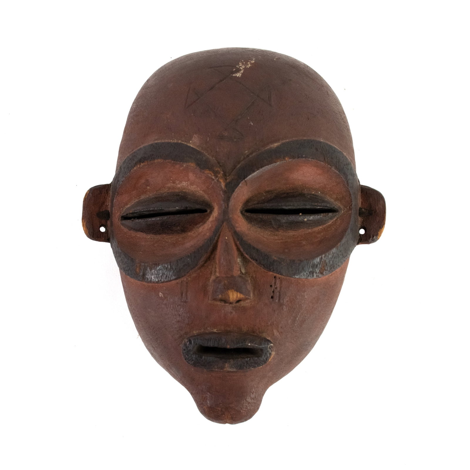 African Chokwe Pwo Hand-Carved Mask: An African Chokwe Pwo hand-carved mask depicting a person's face with exaggerated features and large circular motifs around the eyes.