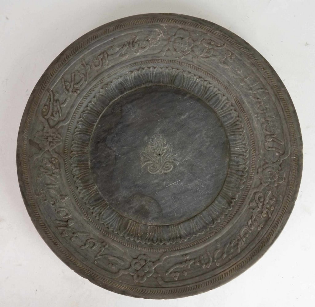 PERSIAN ANTIQUE CARVED GREY STONE CHARGER: Persian stone charger with carved decoration. Note: Each lot in this auction was stored in an active industrial warehouse. Accordingly, lots may exhibit dust and/or surface residue and may benefit fro