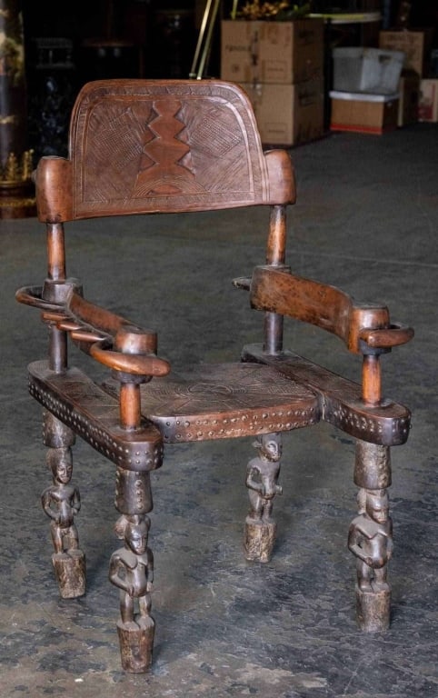 AFRICAN ANTIQUE HAND-CARVED CHIEF CHAIR: African antique hand-carved chief chair figural support, nail head accents. Note: Each lot in this auction was stored in an active industrial warehouse. Accordingly, lots may exhibit dust and/or surfa
