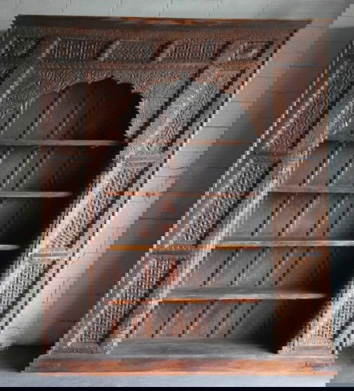 INDIAN ANTIQUE MONUMENTAL HAND CARVED BOOKCASE: Indian antique monumental hand carved bookcase circa 19th century. Window surround made into a bookcase. Note: Each lot in this auction was stored in an active industrial warehouse. Accordingly, lots