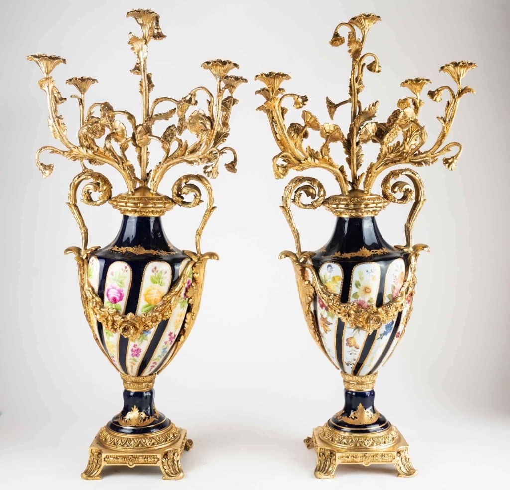 FRENCH SEVRES STYLE PORCELAIN GILT CANDELABRA: Pair of French serves style porcelain gilt candelabra louis xvi porcelain candelabras pair of porcelain urns with brass candelabra mounts. Note: Each lot in this auction was stored in an active indust