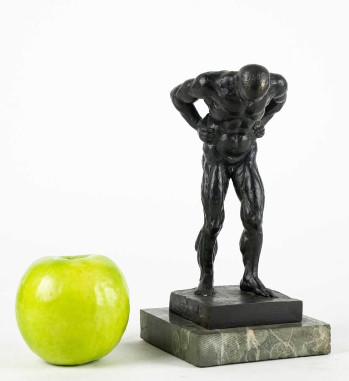SMALL PATINATED BRONZE MALE NUDE ON MARBLE: 20th century, apparently unsigned; standing male nude with hands on hips, dark patinated bronze on integral plinth, raised on a variegated green marble base. Note: Each lot in this auction was stored
