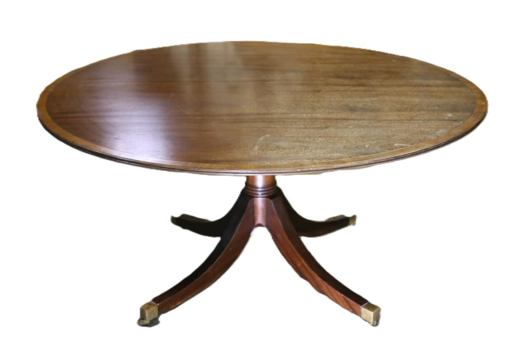 ENGLISH BANDED MAHOGANY CASTORED DINING TABLE: English banded Mahogany dining table splayed base, brass caster legs. Note: Each lot in this auction was stored in an active industrial warehouse. Accordingly, lots may exhibit dust and/or surface res