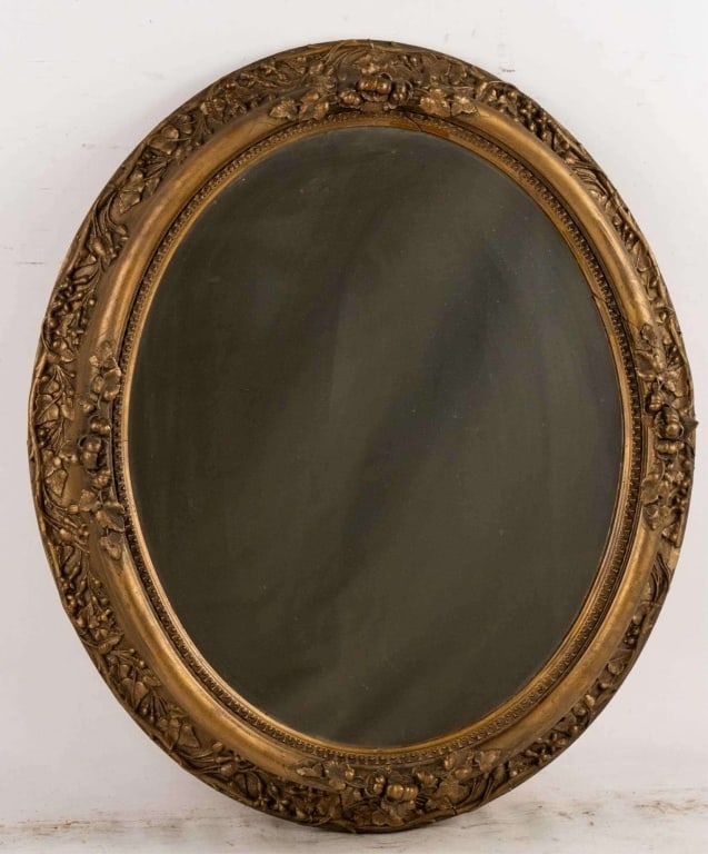 OVAL CARVED GILT WOOD MIRROR: Oval carved Gilt wood mirror. Note: Each lot in this auction was stored in an active industrial warehouse. Accordingly, lots may exhibit dust and/or surface residue and may benefit from cleaning. Appr