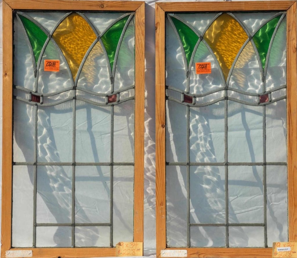 PAIR OF ANTIQUE ENGLISH STAINED GLASS PANELS: Pair of antique English stained glass panels with textured colorless glass accents and amber, green, and red abstract glass elements. Approximate dimensions: h. 34", w. 19" Disclaimer: This is an onli