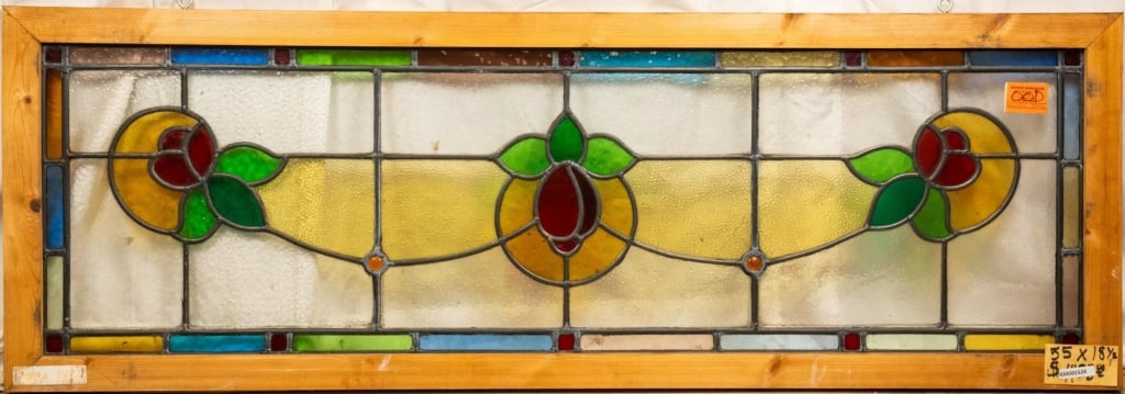 FRENCH ART NOUVEAU STAINED JEWELED GLASS PANEL: French Art Nouveau stained jeweled glass panel with a floral central medallion, two symmetrical floral elements, and jeweled details. Approximate dimensions: h. 18.5" w. 55" Disclaimer: This is an onl