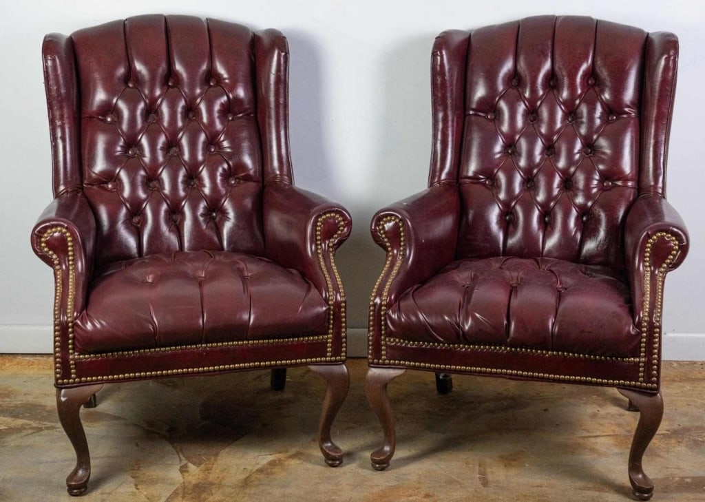 PAIR OF CHESTRFIELD STYLE OXBLOOD WINGBACK CHAIRS: Pair of Chesterfield style oxblood wingback chairs with nail-head trim accents and carved legs. Approximate dimensions: h. 39", w. 29", d. 32" Disclaimer: This is an online court ordered bankruptcy sa