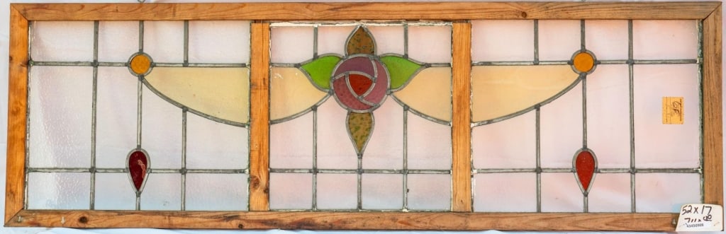 FRENCH ART NOUVEAU STAINED GLASS PANEL: French Art Nouveau stained glass panel with rose motif, accented with amber and red details, set within colorless leaded glass panels. Approximate dimensions: h. 17", w. 52" Disclaimer: This is an onl