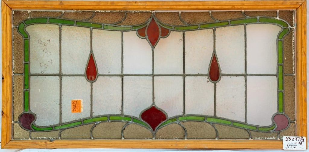 FRENCH ART NOUVEAU STAINED GLASS PANEL: French Art Nouveau stained glass panel with colorless textured leaded glass panels and green, red, and purple stained glass details. Approximate dimensions: h. 23", w. 47.5" Disclaimer: This is an onl