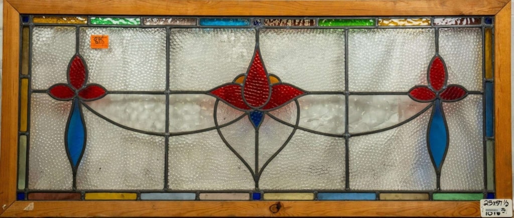 FRENCH ART NOUVEAU STAINED GLASS PANEL: French Art Nouveau stained glass panel with central red flower medallion and symmetrical blue and red floral accents on each side. Approximate dimensions: h. 25", w. 57.5" Disclaimer: This is an onlin