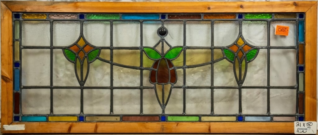 FRENCH ART NOUVEAU JEWELED STAINED GLASS PANEL: French Art Nouveau jeweled stained glass panel with a floral central medallion, flanked by two symmetrical floral elements and enhanced with jeweled details. Approximate dimensions: h. 21", w. 50" Dis