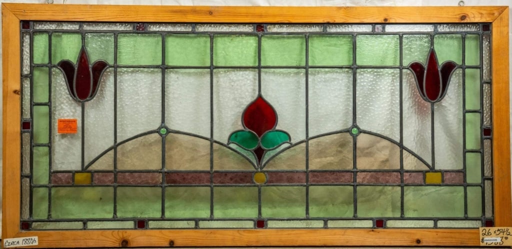 FRENCH ART NOUVEAU JEWELED STAINED GLASS PANEL: French Art Nouveau jeweled stained glass panel with a floral central medallion, flanked by two symmetrical floral elements and adorned with jeweled accents. Approximate dimensions: h. 26", w. 54.5" Di