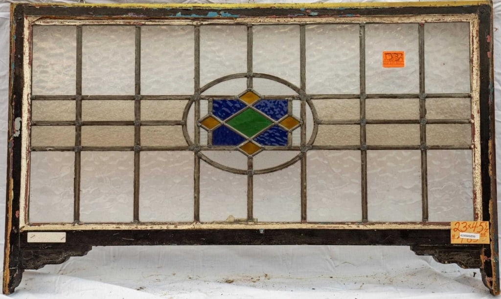 FRENCH ART NOUVEAU STAINED GLASS PANEL: French Art Nouveau stained glass panel composed of a central medallion in blue, green, and amber stained glass. Approximate dimensions: h. 23", w. 45.5" Disclaimer: This is an online court ordered ban