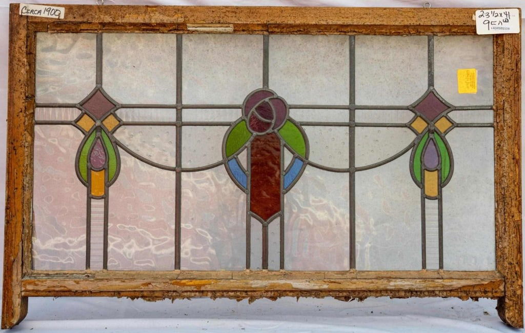 FRENCH ART NOUVEAU STAINED GLASS PANEL: French Art Nouveau stained glass panel with a central floral medallion and two symmetrical abstract elements to the sides. Approximate dimensions: h. 23.5", w. 41" Disclaimer: This is an online court