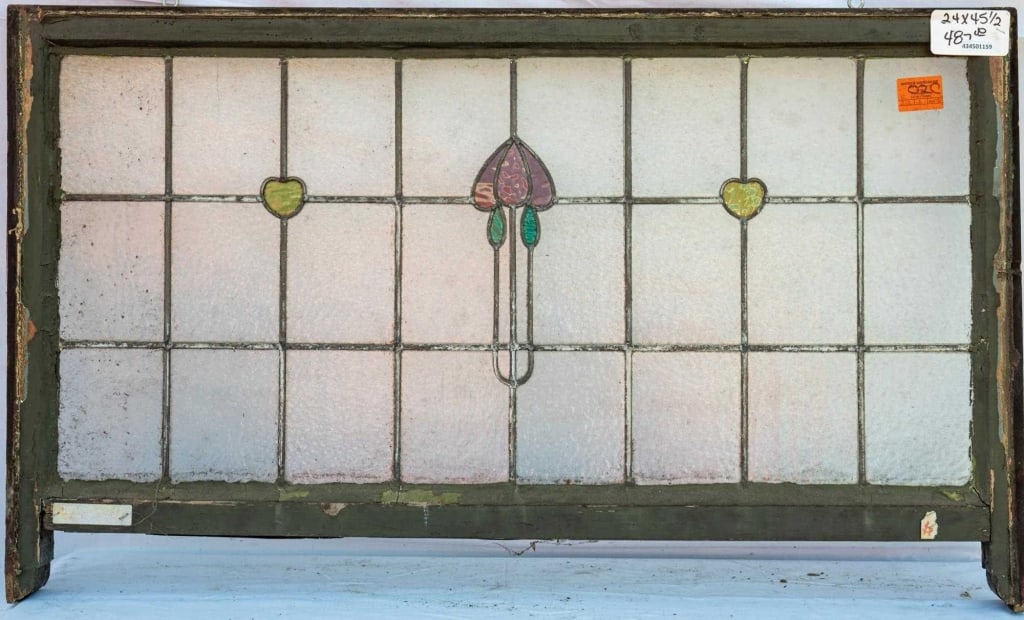FRENCH ART NOUVEAU STAINED GLASS PANEL: French Art Nouveau stained glass panel with a purple floral medallion, green leaves, and two green heart-shaped accents. Approximate dimensions: h. 24", w. 45.5" Disclaimer: This is an online court or