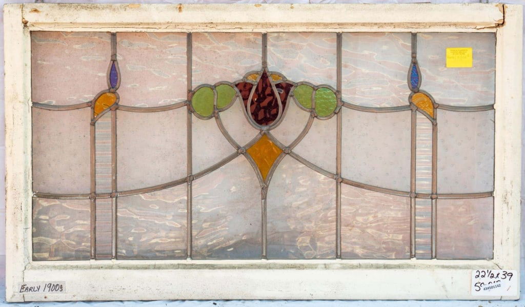 FRENCH ART NOUVEAU STAINED GLASS PANEL: French Art Nouveau stained glass panel with a central red tulip medallion surrounded by green, blue, and yellow stained glass accents. Approximate dimensions: h. 22.5", w. 39" Disclaimer: This is an o