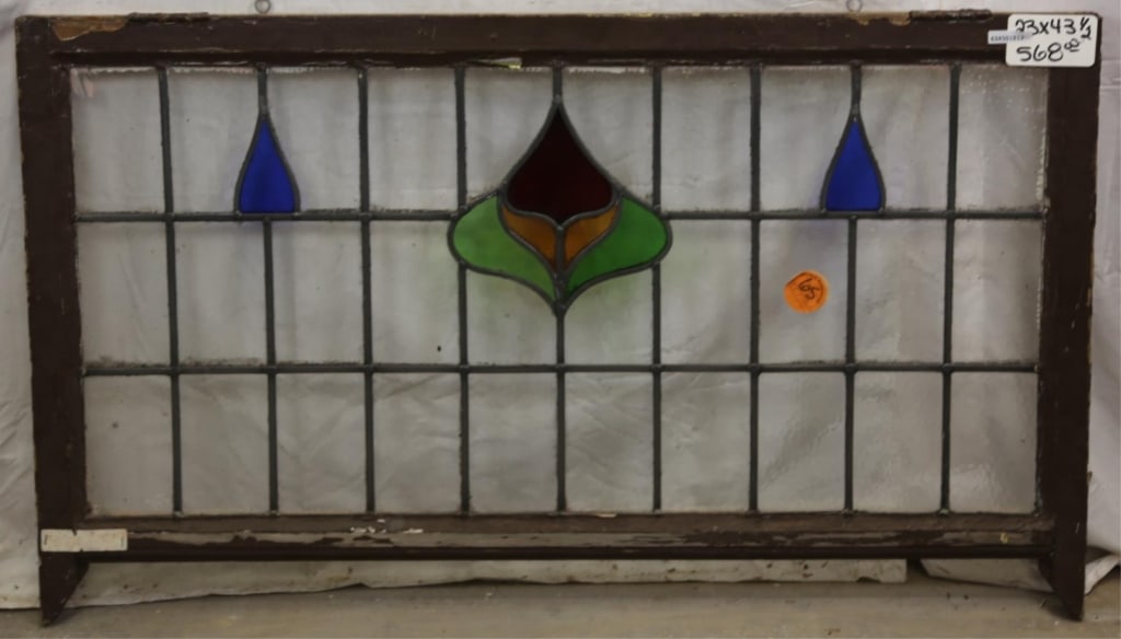 ANTIQUE IRISH STAINED GLASS PANEL: Antique Irish stained glass panel with floral motif medallion and blue stained glass accents to the sides. Approximate dimensions: h. 23", w. 43.5" Disclaimer: This is an online court ordered bankrupt