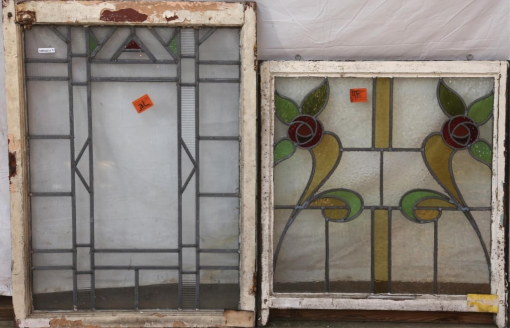 TWO ANTIQUE CONTINENTAL STAINED GLASS PANELS: Two antique Continental stained glass panels, one with geometric colorless leaded glass panels and green and red accents, the other with symmetrical floral elements. Approximate dimensions: h. 37.5",