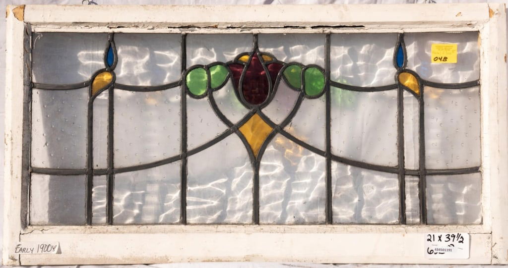 FRENCH ART NOUVEAU STAINED GLASS PANEL: French Art Nouveau stained glass panel with a central red tulip medallion flanked by blue and yellow accents. Approximate dimensions: h. 21", w. 39.5" Disclaimer: This is an online court ordered bankr