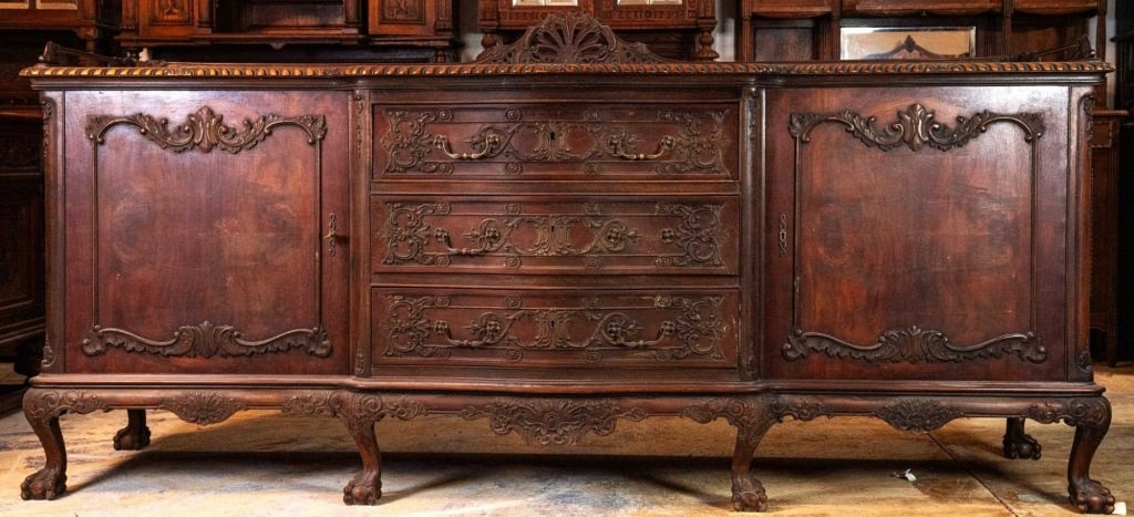 FRENCH CARVED MAHOGANY SIDEBOARD: French carved mahogany sideboard with ball-and-claw feet, elaborately carved shell-shaped crest, carved inset panels, and green felt lining in the top drawer. Approximate dimensions: h. 48.5", w. 101"