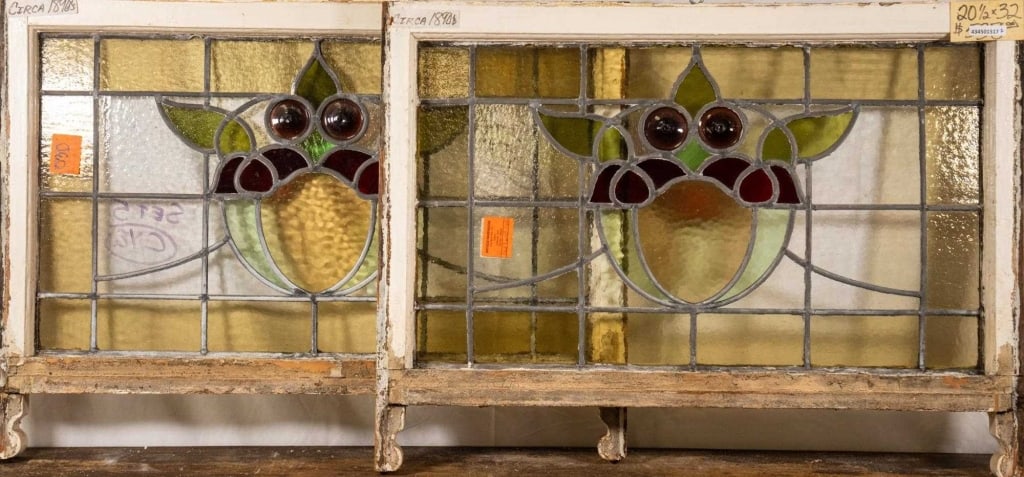 PAIR OF FRENCH ART NOUVEAU JEWLED STAINED GLASS PA: Pair of French Art Nouveau jeweled stained glass panels, each with two purple jeweled details and a floral medallion. Approximate dimensions: h. 20.5", w. 32" Disclaimer: This is an online court order