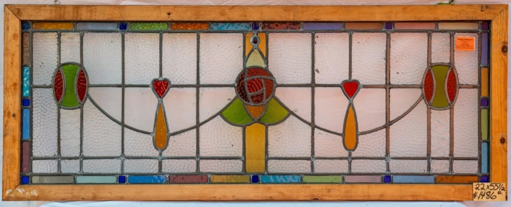 FRENCH ART NOUVEAU STAINED GLASS PANEL: French Art Nouveau stained glass panel with a red glass rose, accented with green, red, and amber stained glass elements. Approximate dimensions: h. 22.5", w. 55.5" Disclaimer: This is an online court