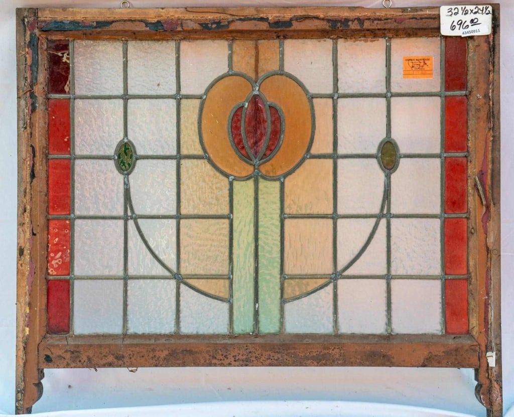 FRENCH ART NOUVEAU STAINED GLASS PANEL: French Art Nouveau stained glass panel with an amber and red floral motif, set within red and amber leaded glass panels. Approximate dimensions: h. 24.5", w. 32.5" Disclaimer: This is an online court