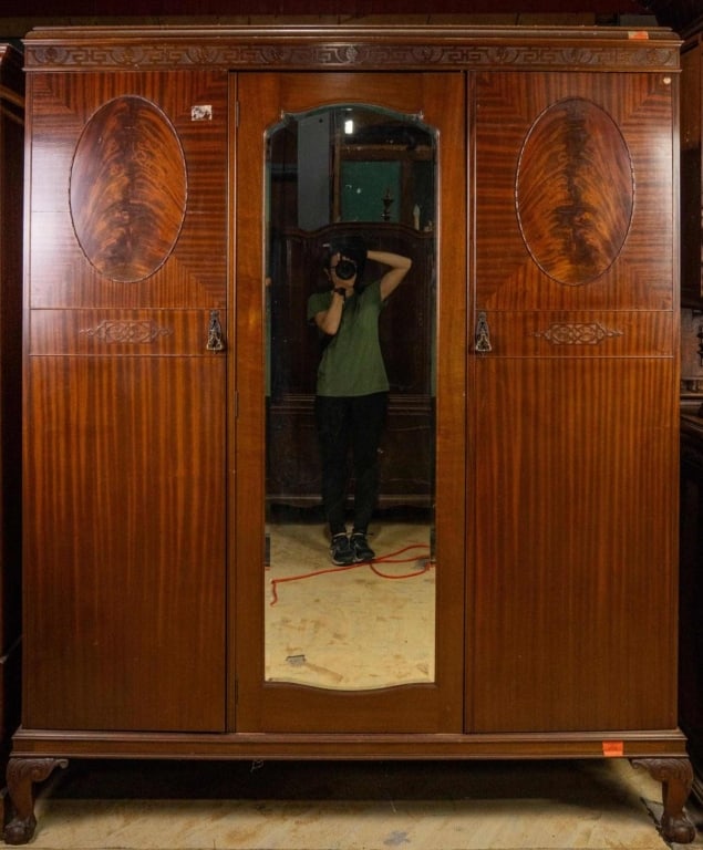 ENGLISH CHIPPENDALE STYLE TRIPLE ARMOIRE: English Chippendale style triple armoire with claw-and-ball feet, carved details, and beveled mirror. Approximate dimensions: h. 81.5", w. 69", d. 21" Disclaimer: This is an online court ordered bankr