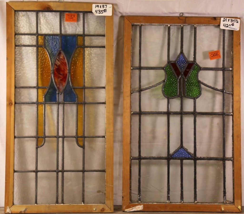 TWO ANTIQUE CONTINENTAL STAINED GLASS PANELS: Two antique Continental stained glass panels, one with textured shield-form medallion and the other with abstract amber and blue medallion with red wispy glass detail. Approximate dimensions: h. 37",