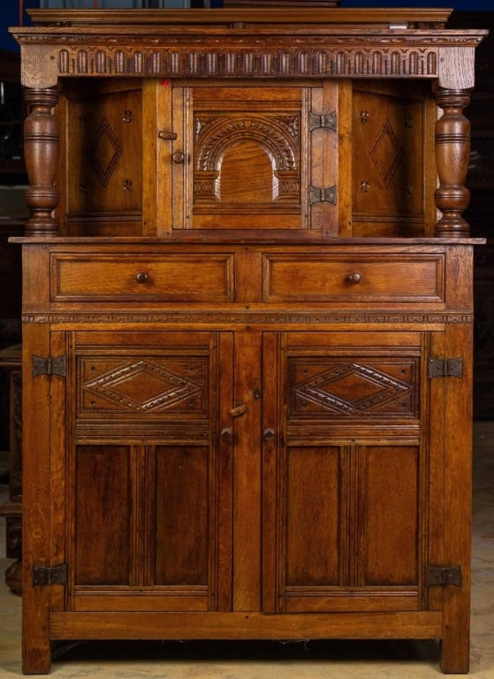 FRENCH OAK COURT CUPBOARD: French oak court cupboard with carved inset panels, wood-turned pulls, and carved supports. Approximate dimensions: h. 57.5", w. 42", d. 16" Disclaimer: This is an online court ordered bankruptcy sale