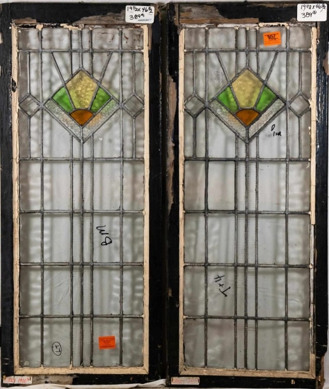 PAIR OF FRENCH ART DECO STAINED GLASS PANELS: Pair of French Art Deco stained glass panels with amber, canary yellow, and green geometric medallions, and colorless leaded glass panels. Approximate dimensions: h. 46.5", w. 19.5" Disclaimer: This i