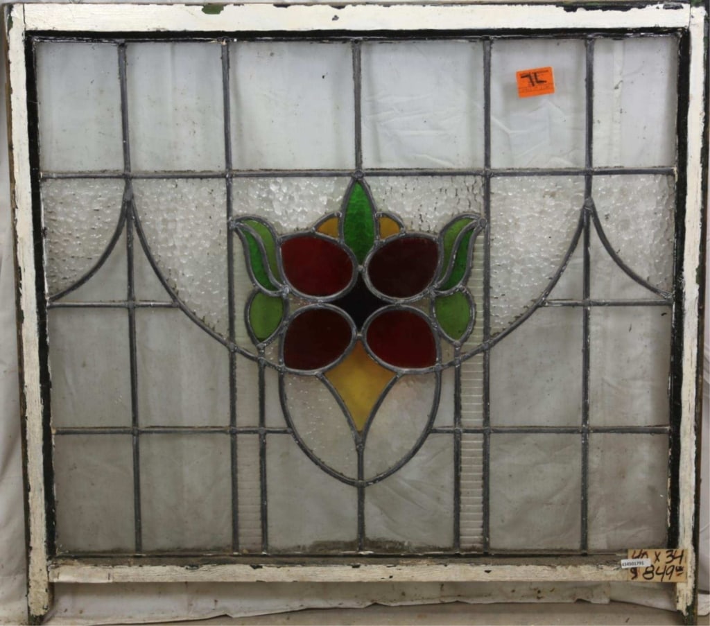 ANTIQUE ENGLISH STAINED GLASS PANEL: Antique English stained glass panel with floral medallion, red, purple, and amber details, and green leaf accents. Approximate dimensions: h. 34", w. 40" Disclaimer: This is an online court ordered ba