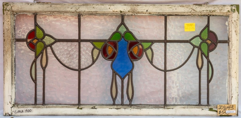 FRENCH ART NOUVEAU STAINED GLASS PANEL: French Art Nouveau stained glass panel with floral central motif with two symmetrical floral elements to the sides. Approximate dimensions: h. 20.5", w. 43" Disclaimer: This is an online court ordered