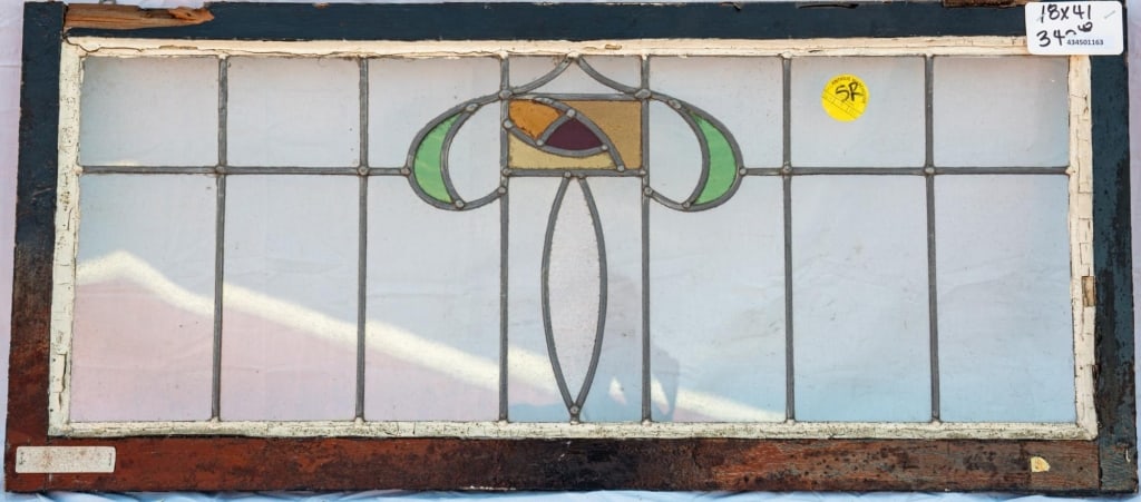 CONTINENTAL STAINED GLASS PANEL: Continental stained glass panel with an abstract stained glass medallion. Approximate dimensions: h. 18", w. 41" Disclaimer: This is an online court ordered bankruptcy sale. Participating bidders must